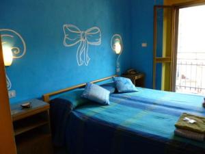 a blue bedroom with a bed with a bow on the wall at Hotel San Giovanni in Milan