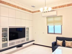 - un salon avec une télévision et un canapé dans l'établissement Yilan NAI-JI House, à Dongshan