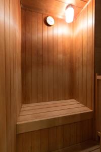 a sauna with a clock on a wooden wall at HOTEL D-WAVE Shinjuku（Adult Only) in Tokyo