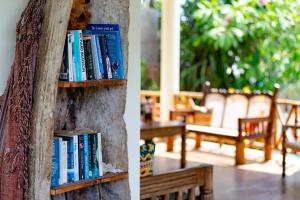un estante de libros con libros al lado de un banco en Villa Mashariki - luxury villa 400m from the beach, en Diani Beach