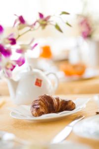 ein Croissant auf einem Teller auf einem Tisch in der Unterkunft Hotel Candido in Diano Marina