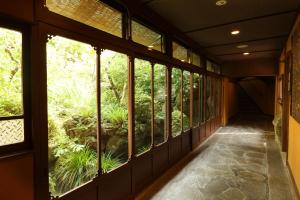 a hallway with windows and a garden outside at Hakone Onsen Ryokan Yaeikan in Hakone