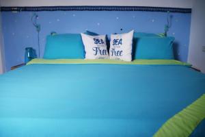 Una cama azul con dos almohadas. en Blue Lagoon with Pool, en Eilat