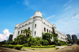 a large white building with palm trees in front of a street at The Castle Ballet Taichung A Boutique Hotel in Taichung