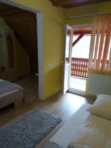 een slaapkamer met een bed en een deur naar een balkon bij Casa VIO in Sighişoara