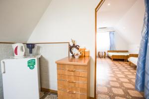 a kitchen with a refrigerator and a living room at Guest House Sadochek in Sevastopol