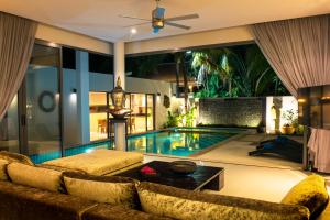 ein Wohnzimmer mit Pool und Couch in der Unterkunft Amazing 5br, Seaview private PoolVilla by Intira Villas in Rawai Beach