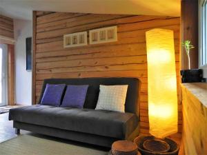 um sofá sentado numa sala de estar com dois candeeiros em Aliai em Utena