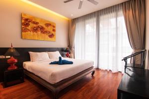 ein Schlafzimmer mit einem Bett mit einem blauen Handtuch darauf in der Unterkunft Amazing 5br, Seaview private PoolVilla by Intira Villas in Rawai Beach + 18 Fotos