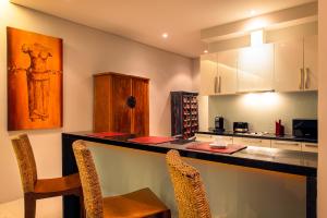 eine Küche mit einer Bar mit 2 Stühlen und einer Arbeitsplatte in der Unterkunft Amazing 5br, Seaview private PoolVilla by Intira Villas in Rawai Beach
