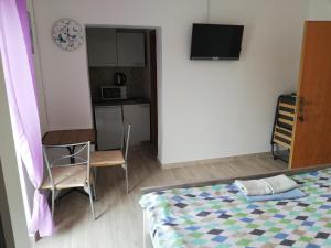 a bedroom with a bed and a table and a kitchen at Guesthouse Martina in Senj