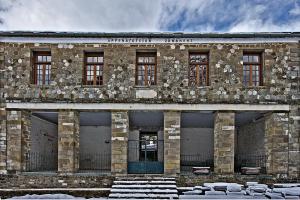 an old stone building with a blue door at Kato Machalas in Dikoryfo