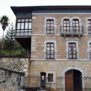 ein altes Backsteingebäude mit Fenstern und einem Baum in der Unterkunft Palacete Peñanora in Oviedo