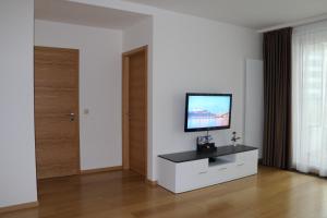 sala de estar con TV en una pared blanca en Panorama City Apartment with Free Parking, en Bratislava