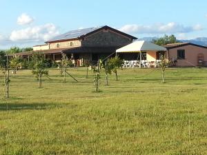 a building with a field with trees in front of it at Country House Casale D'Orio in Ascea