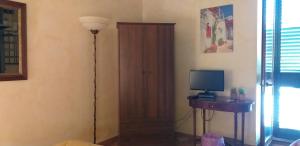 アチレアーレにあるVilla Caratiのドア、デスク、テレビが備わる客室です。