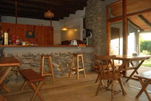 a kitchen with a table and chairs and a stone wall at Hotel El Refugio nudista naturista opcional in Chihuahua