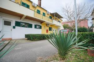 ein gelbes und weißes Gebäude mit einer Palme davor in der Unterkunft Roko in Zadar