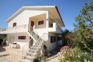 une maison blanche avec des escaliers en face de celle-ci dans l'établissement Moradia Vale da Telha, à Aljezur