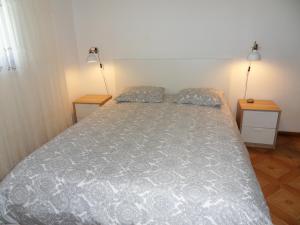 アルジェズールにあるMoradia Vale da Telhaのベッドルーム(ナイトスタンド2つ、ランプ2つ付)のベッド1台