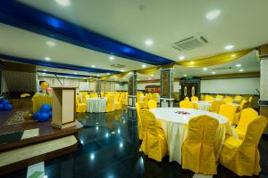 a banquet hall with white tables and yellow chairs at AB Inn Hotel in Kulai