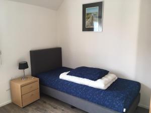 ein kleines Schlafzimmer mit einem Bett und einem Nachttisch in der Unterkunft Meeuw in Hollum