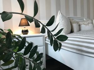 a bedroom with a bed with a plant and a lamp at AquaGate Jurmala in Jūrmala