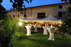 un grupo de mesas y sillas en un jardín por la noche en Agriturismo Le Caldane, en Colà di Lazise