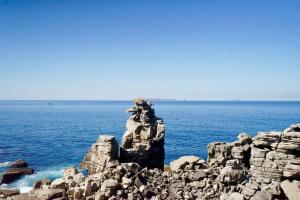 a statue on top of a rock in the ocean at Deluxe Oceanfront - Vue Sur la Mer in Peniche