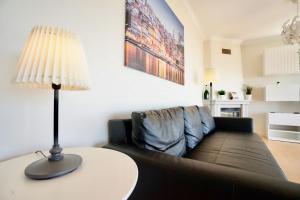 a living room with a couch and a table with a lamp at Deluxe Oceanfront - Vue Sur la Mer in Peniche