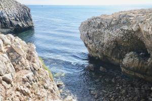 a view of the ocean between two rocky cliffs at Deluxe Oceanfront - Vue Sur la Mer in Peniche