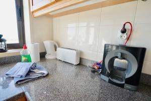 a kitchen counter with a microwave on a counter top at Deluxe Oceanfront - Vue Sur la Mer in Peniche