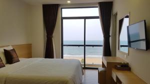 a bedroom with a bed and a view of the beach at Galaxy Hotel in Quy Nhon