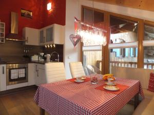a kitchen with a table with a red and white table cloth at Ferienwohnung Alpenstern in Rieden am Forggensee