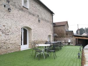 a patio with tables and chairs and a building at Gîte chezmadlou in Colondannes