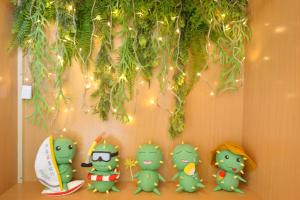 a group of green figurines on a wall with lights at PHSEA INN in Magong