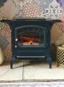 una stufa nera con un fuoco in una stanza di Eden's House a Hexham