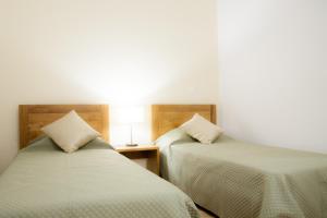 2 Betten nebeneinander in einem Zimmer in der Unterkunft Quinta de Trancoso in Carnicãis