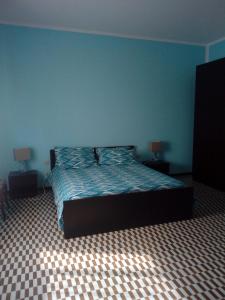 Schlafzimmer mit einem Bett mit blauer Wand in der Unterkunft B&B DE CAROL in Gramignazzo