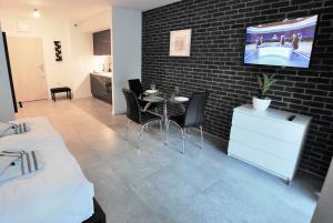 a room with a table and a tv on a brick wall at Paragraf Apartament in Łódź