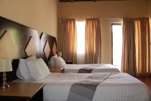 a hotel room with two beds and a window at Black Swan Guesthouse in Maseru +42 photos