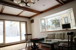 a living room with a couch and a table at Hostel Jumpu Manpan in Otaru