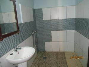 een badkamer met een wastafel, een toilet en een spiegel bij Residence Kathyly in Diego Suarez