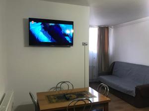 a living room with a couch and a tv on the wall at Studio Luigy in Turda
