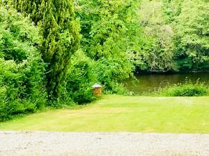 a park with a bench next to a river at Apartment 42a by the River in Inverness