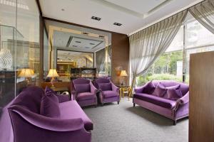 a hotel room with purple chairs and a mirror at Taipei Garden Hotel - Ximending in Taipei