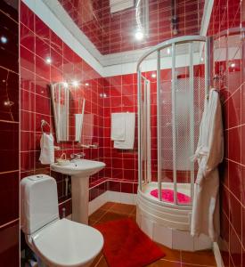 a red tiled bathroom with a shower and a toilet at Voskresenskaya Hotel in Cherepovets