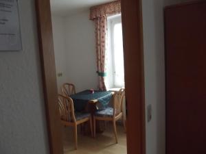 Zimmer mit einem Tisch, Stühlen und einem Fenster in der Unterkunft Hotel Haus Irsfeld in Waxweiler