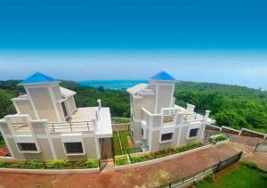 una casa bianca con cupole blu in cima di The Blue View - sea view villas a Ratnagiri