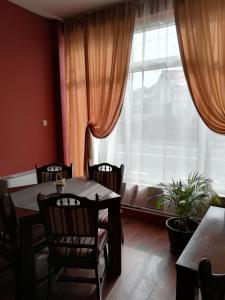 a dining room with a table and chairs and a window at Provincial in Vişeu de Jos +33 photos